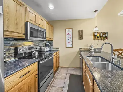 a kitchen with a sink and a stove at B6 Tarn Landing 1Br Loft, 3Ba condo in Frisco