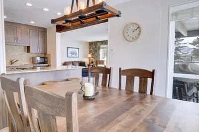 a kitchen and dining room with a wooden table and a clock at E101 Lake Cliffe condo in Dillon