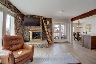 a living room with a stone wall with a fireplace at E101 Lake Cliffe condo in Dillon