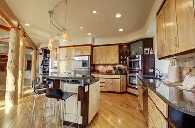 a large kitchen with wooden cabinets and a large island at 11 Stormwatch Circle 4Br 3,5Ba home in Silverthorne