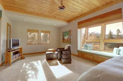 a bedroom with a bed and a tv and windows at 11 Stormwatch Circle 4Br 3,5Ba home in Silverthorne