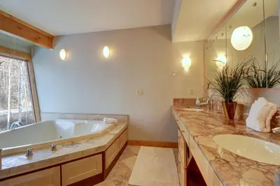 a bathroom with two sinks and a tub and a large mirror at 11 Stormwatch Circle 4Br 3,5Ba home in Silverthorne