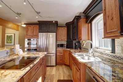 a kitchen with wooden cabinets and a stainless steel refrigerator at 334 Willow Lake Ct, 4Br withloft 3Ba townhouse in Silverthorne