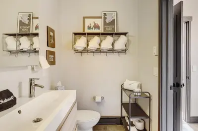 a white bathroom with a toilet and a sink at Silver Lining Circle home in Fraser