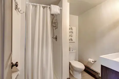 a bathroom with a toilet and a shower curtain at Silver Lining Circle home in Fraser