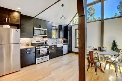 a kitchen with stainless steel appliances and a table at Silver Lining Circle home in Fraser