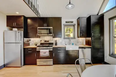 a kitchen with wooden cabinets and stainless steel appliances at Silver Lining Circle home in Fraser
