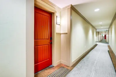 a red door in a hallway with a hallway at Walk to Slopes Granby Condo with Balcony! in Granby