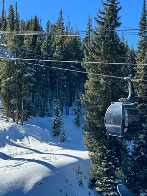 a ski lift in the snow with snow covered trees at Ski Run 303 by SummitCove Lodging in Keystone