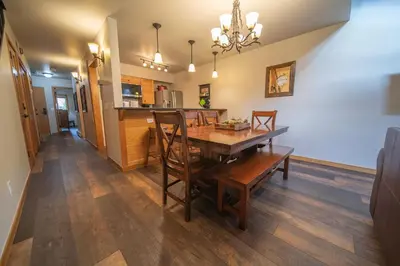 a dining room and kitchen with a wooden table and chairs at Ski Run 303 by SummitCove Lodging in Keystone