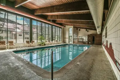 a swimming pool in a building with windows at Ski Run 303 by SummitCove Lodging in Keystone