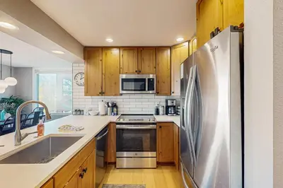 a kitchen with wooden cabinets and a stainless steel refrigerator at Crisp Mountain Retreat in Winter Park