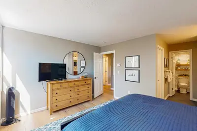 a bedroom with a bed and a tv and a mirror at Crisp Mountain Retreat in Winter Park