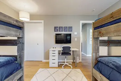 a bedroom with two bunk beds and a desk with a computer at Crisp Mountain Retreat in Winter Park