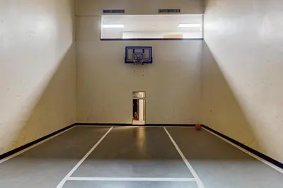 an empty gymnasium with a basketball hoop on the wall at Crisp Mountain Retreat in Winter Park