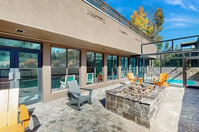 an outdoor patio with a fire pit and chairs at Crisp Mountain Retreat in Winter Park