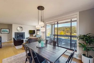 a dining room with a table and a living room at Crisp Mountain Retreat in Winter Park