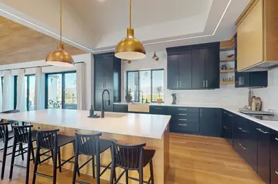 a kitchen with blue cabinets and a large island with chairs at Valley View Retreat | Main House in Tabernash
