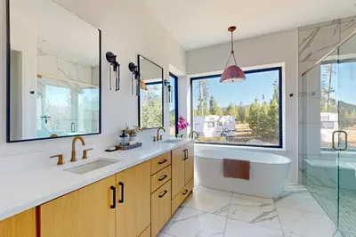 a bathroom with a tub and a sink and a large window at Valley View Retreat | Main House in Tabernash