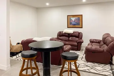 a living room with couches and a table and stools at Valley View Retreat | Main House in Tabernash