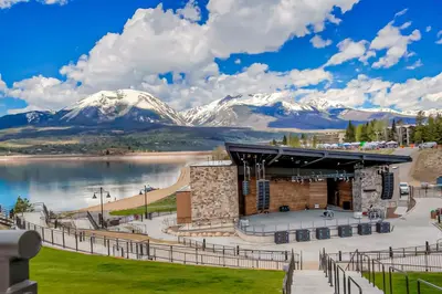 a building with snow covered mountains in the background at Summit Serenity in Dillon