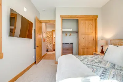 a bedroom with a bed and a door to a kitchen at Modern Condo with Hot Tub 5 Mi to Winter Park! in Fraser