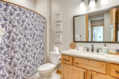 a bathroom with a toilet and a sink and a mirror at Modern Condo with Hot Tub 5 Mi to Winter Park! in Fraser