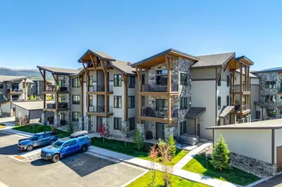 an apartment complex with a blue truck parked in a parking lot at Modern Condo with Hot Tub 5 Mi to Winter Park! in Fraser