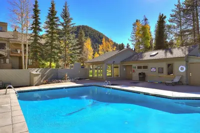 a large blue swimming pool in front of a house at 1147 Flying Dutchman condo in Keystone