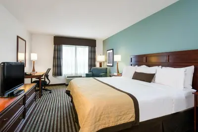 a hotel room with a bed and a flat screen tv at Baymont by Wyndham Denver International Airport in Denver
