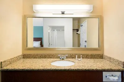 a bathroom with a sink with a large mirror at Baymont by Wyndham Denver International Airport in Denver