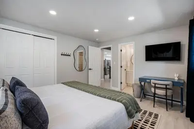 a bedroom with a bed and a table and a mirror at Colorful Getaway Hot Tub Enchanting Yard in Denver