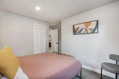 a small bedroom with a bed and a chair at Colorful Getaway Hot Tub Enchanting Yard in Denver