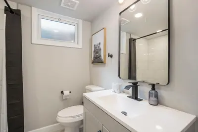 a white bathroom with a sink and a mirror at Colorful Getaway Hot Tub Enchanting Yard in Denver