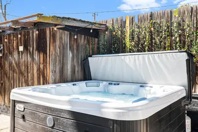 a bath tub sitting next to a wooden fence at Colorful Getaway Hot Tub Enchanting Yard in Denver