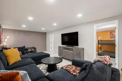 a living room with couches and a flat screen tv at Colorful Getaway Hot Tub Enchanting Yard in Denver