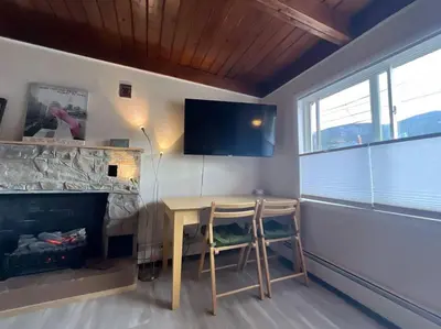 a living room with a table and a fireplace at Large Studio LIGHT & VIEWS - Beautiful with Deck - Message Direct in Idaho Springs