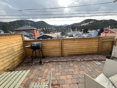a patio with a chair on a wooden fence at Large Studio LIGHT & VIEWS - Beautiful with Deck - Message Direct in Idaho Springs