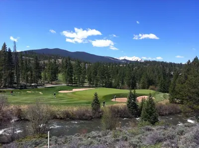 a golf course in the mountains with a river at Flying Dutchman 1110 by SummitCove Lodging in Keystone