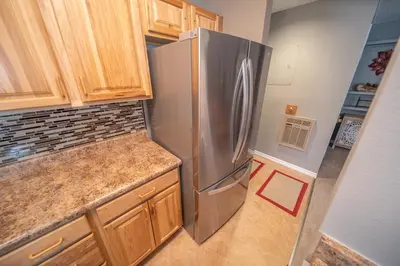 a kitchen with a stainless steel refrigerator and wooden cabinets at Flying Dutchman 1110 by SummitCove Lodging in Keystone