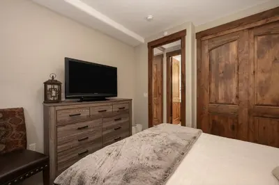 a bedroom with a bed and a television on a dresser at Iron Horse Manor home in Winter Park