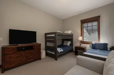 a bedroom with a television and a bunk bed at Iron Horse Manor home in Winter Park