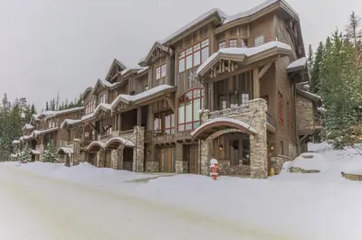 a large building with a fire hydrant in the snow at Iron Horse Manor home in Winter Park