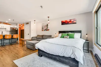 a bedroom with a large bed and a couch at Walk to Dtwn Winter Park Studio with Hot Tub Access in Winter Park