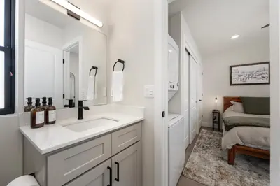 a bathroom with a sink and a mirror and a bed at Luxury Modern Tiny Home in Downtown Fraser in Fraser