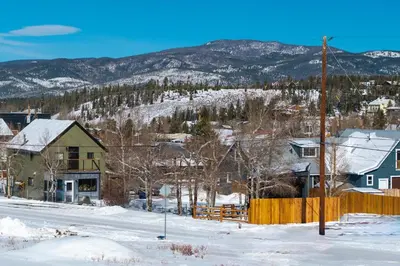 a town in the snow with mountains in the background at Luxury Modern Tiny Home in Downtown Fraser in Fraser