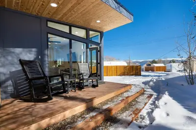 a house with a deck with chairs on it at Luxury Modern Tiny Home in Downtown Fraser in Fraser