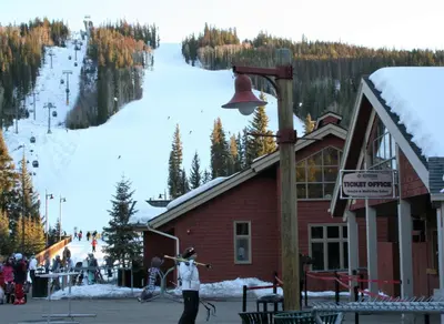 a man standing in front of a ski lodge with a bell at Mill Creek 201 by SummitCove Lodging in Keystone