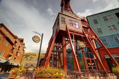 a building with tables and chairs in front of it at Mill Creek 201 by SummitCove Lodging in Keystone