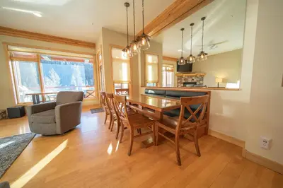 a dining room and kitchen with a wooden table and chairs at Mill Creek 201 by SummitCove Lodging in Keystone